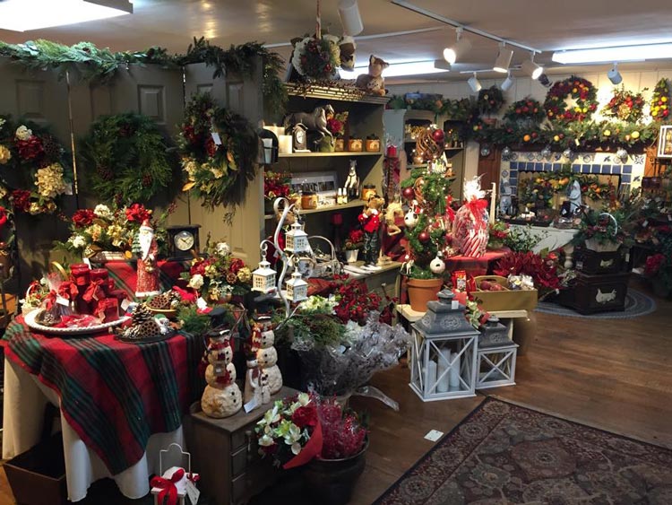 An image of the Matlack gift shop at Christmastime. There are many wreaths and decorations out for sale. Everything is green, red, and white.